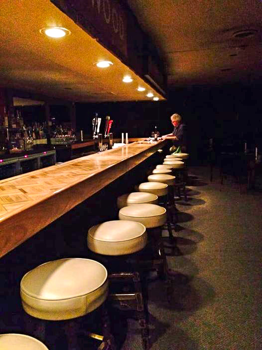 An empty bar with one man sitting at the end