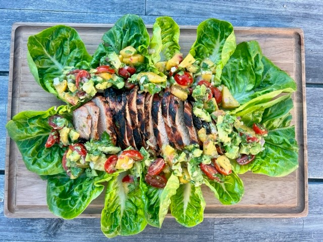 Grilled meat surrounded by lettuce leaves